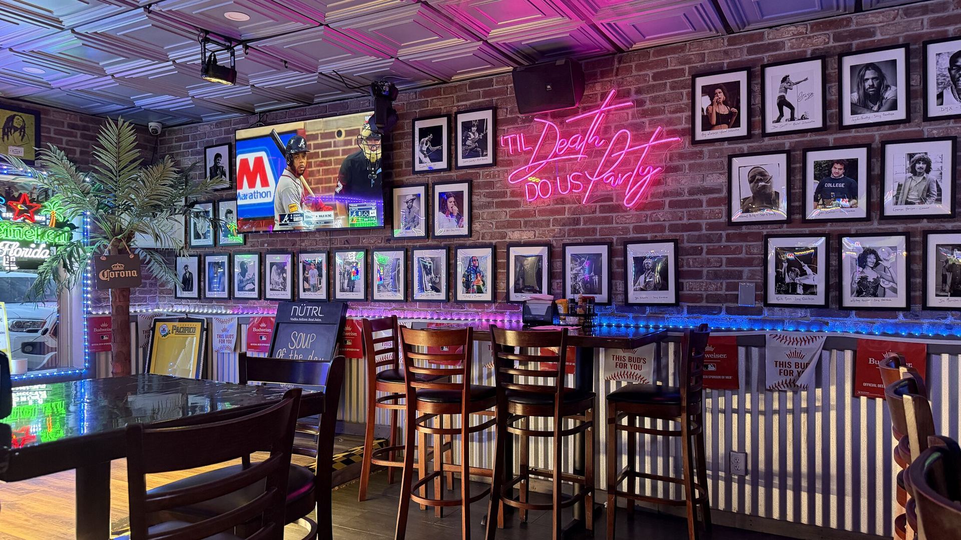 The Legends wall of framed photos beside the 'Til Death Do Us Party neon sign